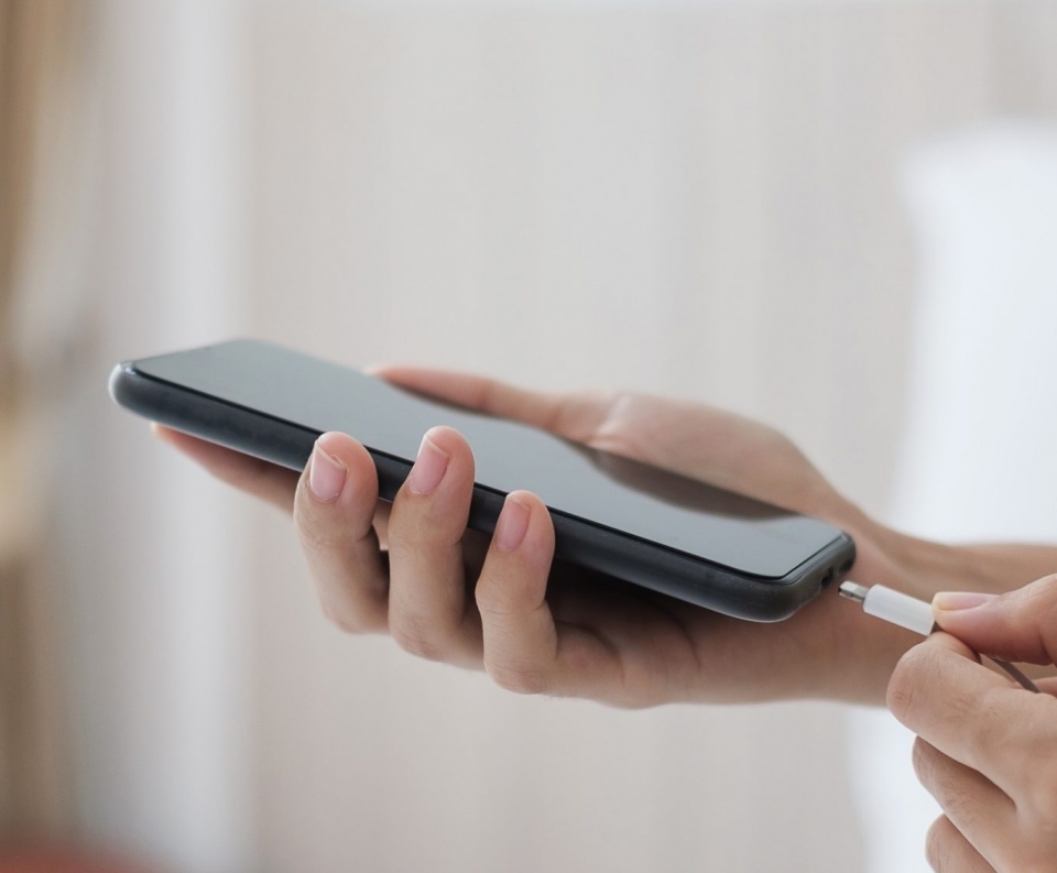 woman-hands-charging-battery-in-mobile-smart-phone-in-the-bedroom-at-home-technology-multiple-sharin